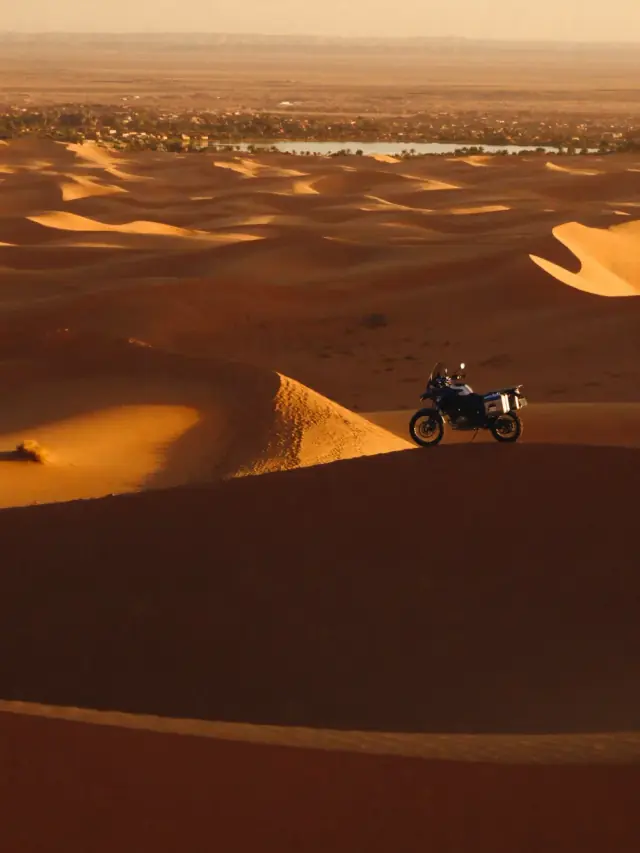 Moto d'aventure au sommet d'une dune du Sahara